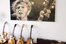 The David Bowie painting in its new home in Monaco in good company of Bowie guitars.